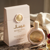 Une présentation de produit haut de gamme de l'Eau de Parfum Mirsaal Passion, présentant le flacon rose pâle de 100ml scellé à la cire à côté de son élégant coffret cadeau assorti, stylisé avec des gousses de vanille et des accents aromatiques sur une surface en marbre.